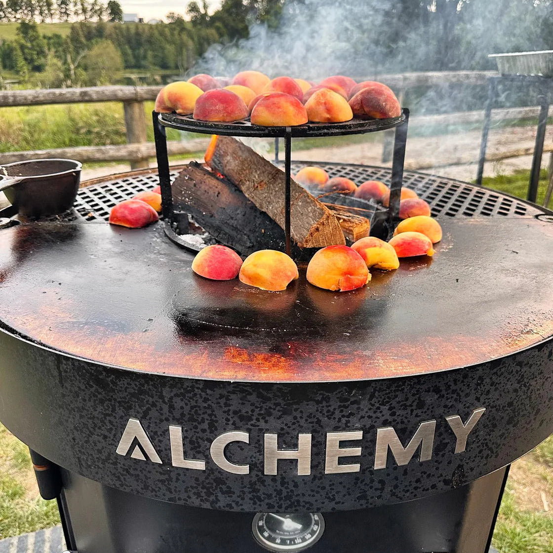 Alchemy barbecue grill with peaches and bread on a outdoor setting