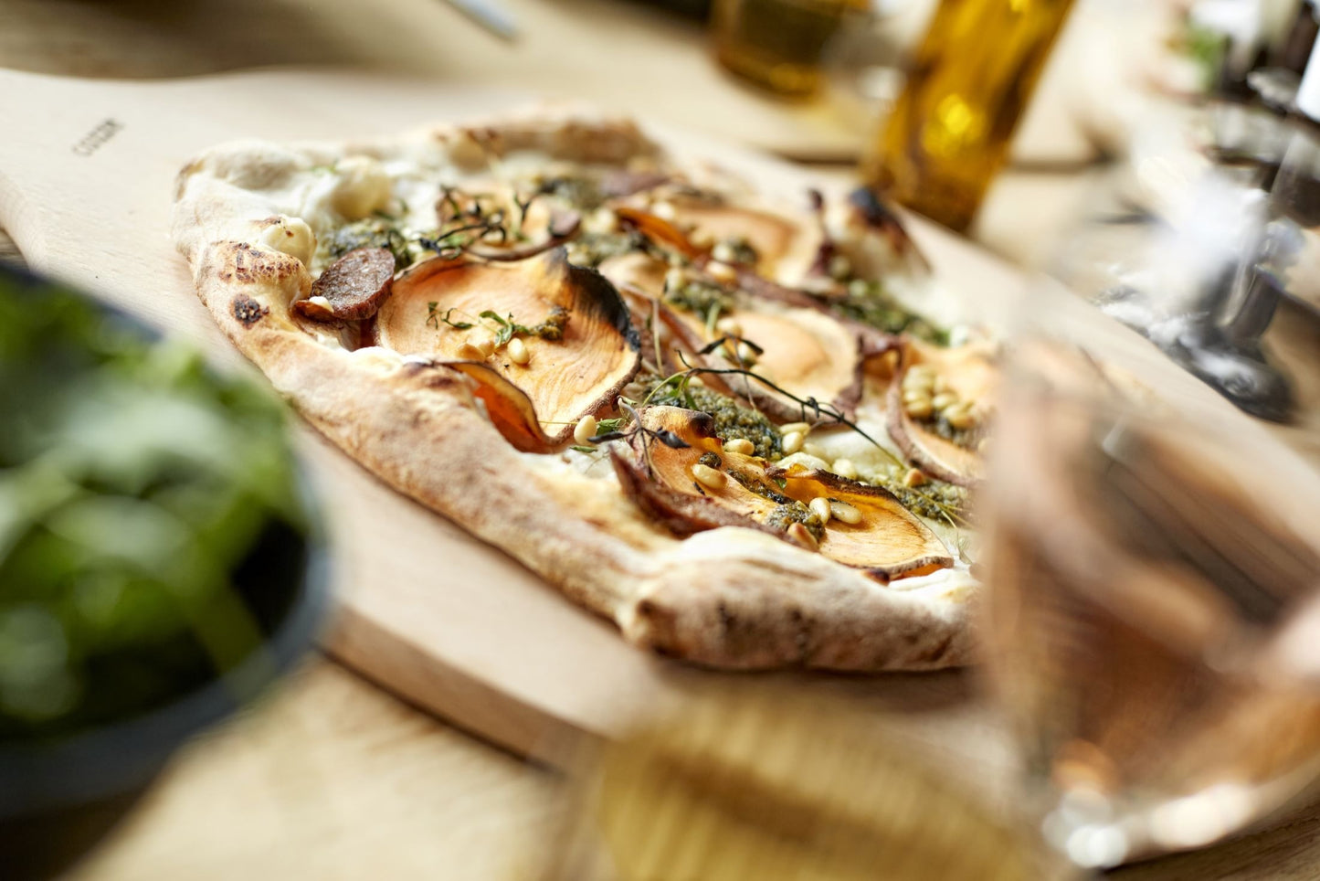 Pizza with mushrooms and herbs on a wooden board