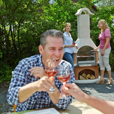 Buschbeck Davos masonry barbecue with base in garden setting