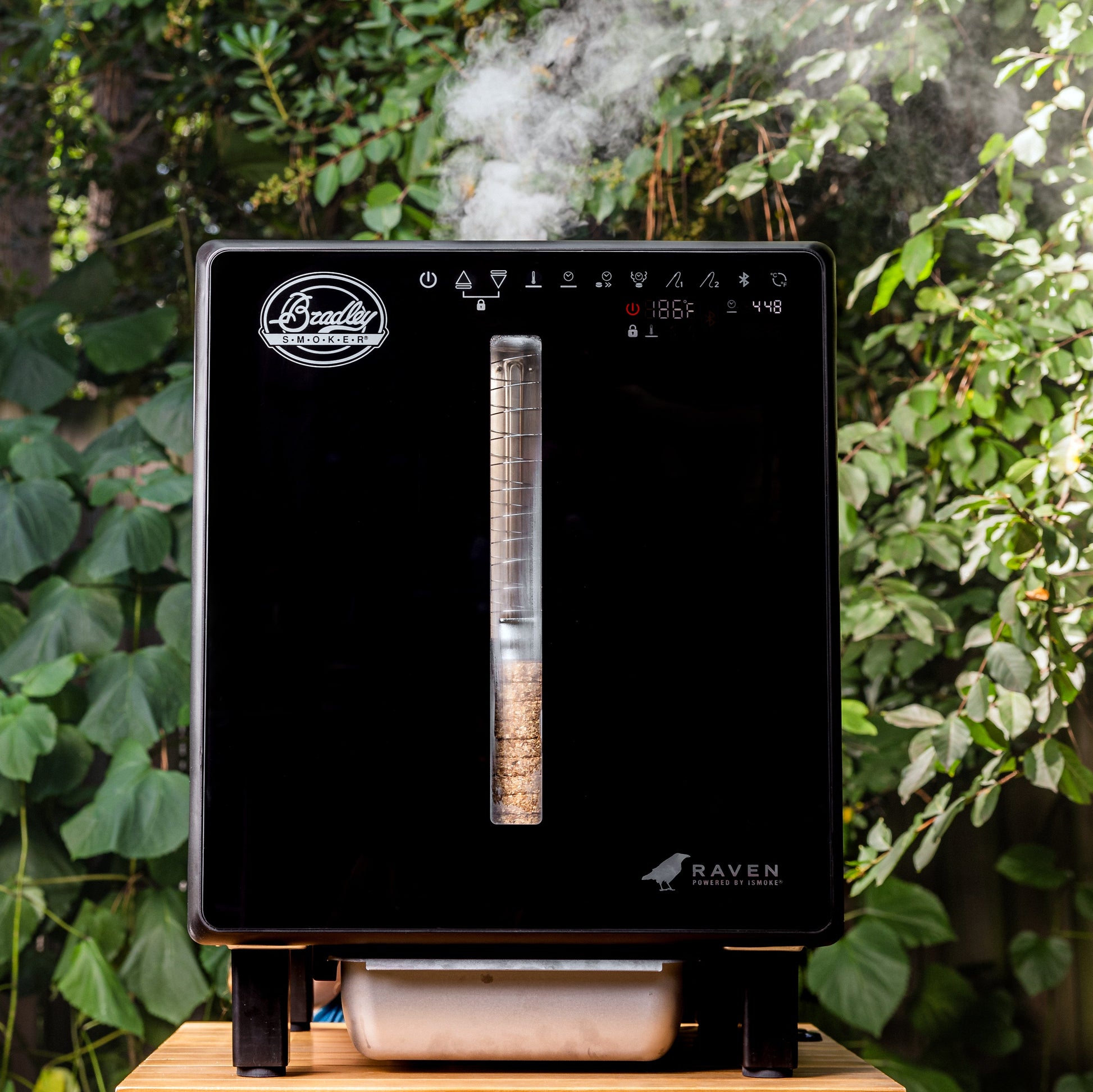 Black smoker with brand logo on a wooden surface outdoors
