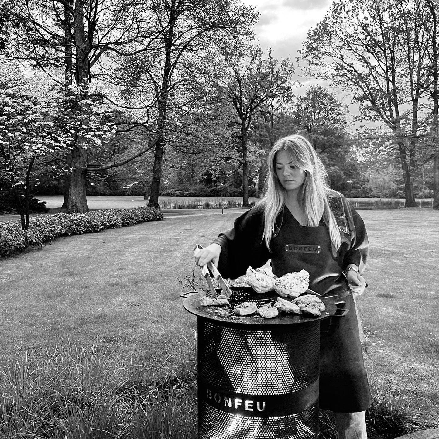 Person grilling outdoors in a Garden setting