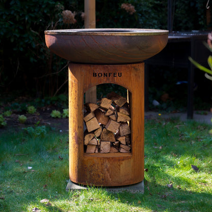 Wooden fire pit with firewood storage on a grassy area