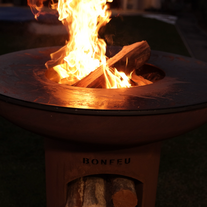 Fire pit with flames glowing in the dark, featuring the brand BonFeu