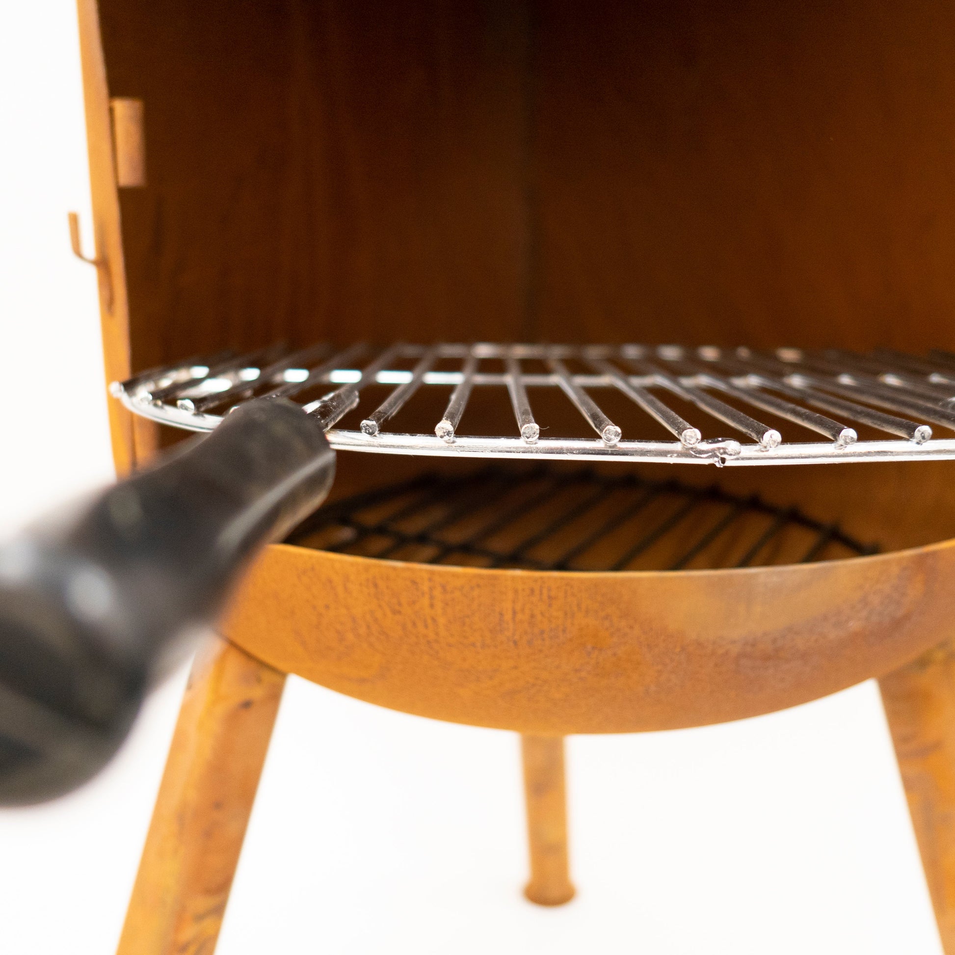 Wooden barbecue grill with a metal grate on a white background