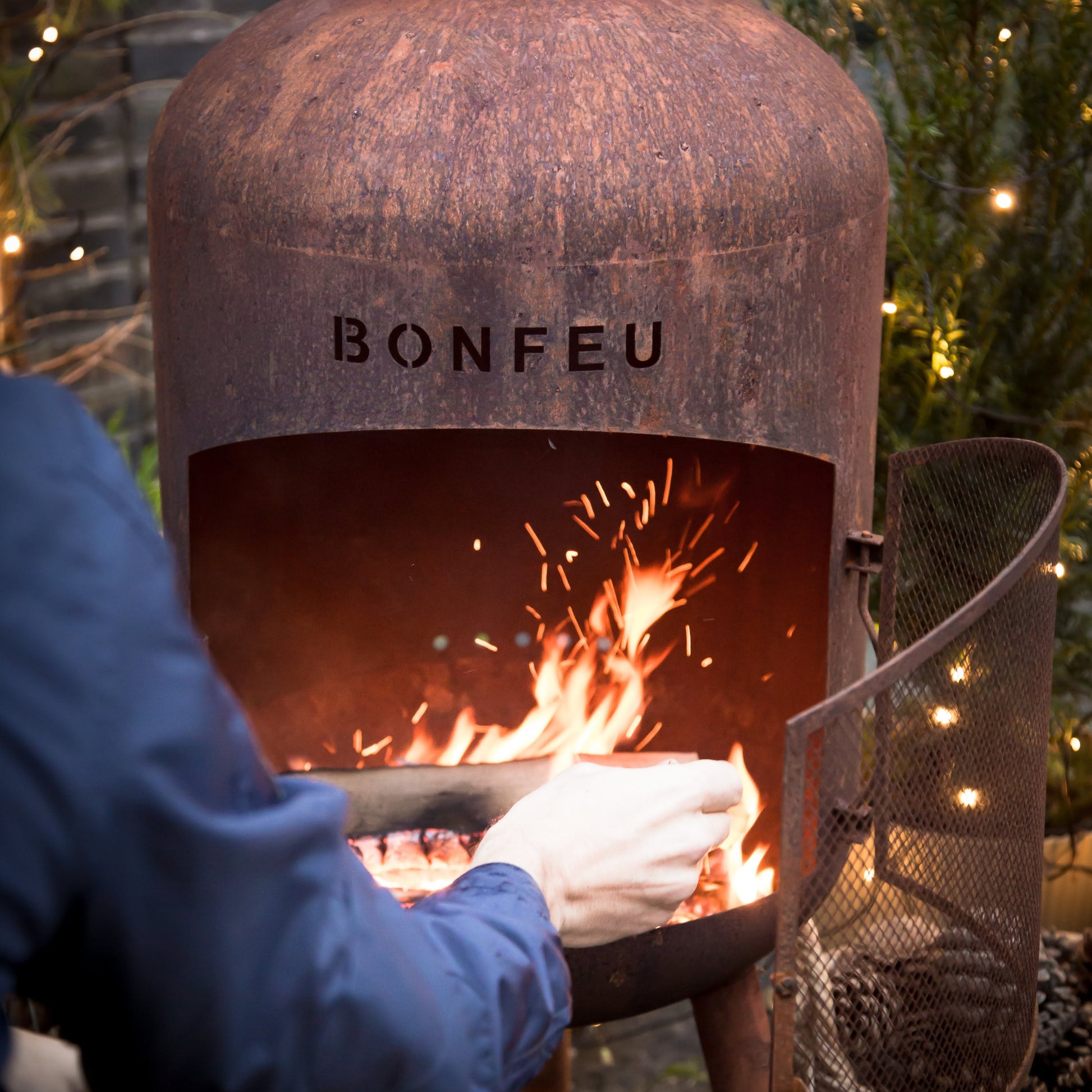 Person using a Bonfeu fire pit with flames and sparks