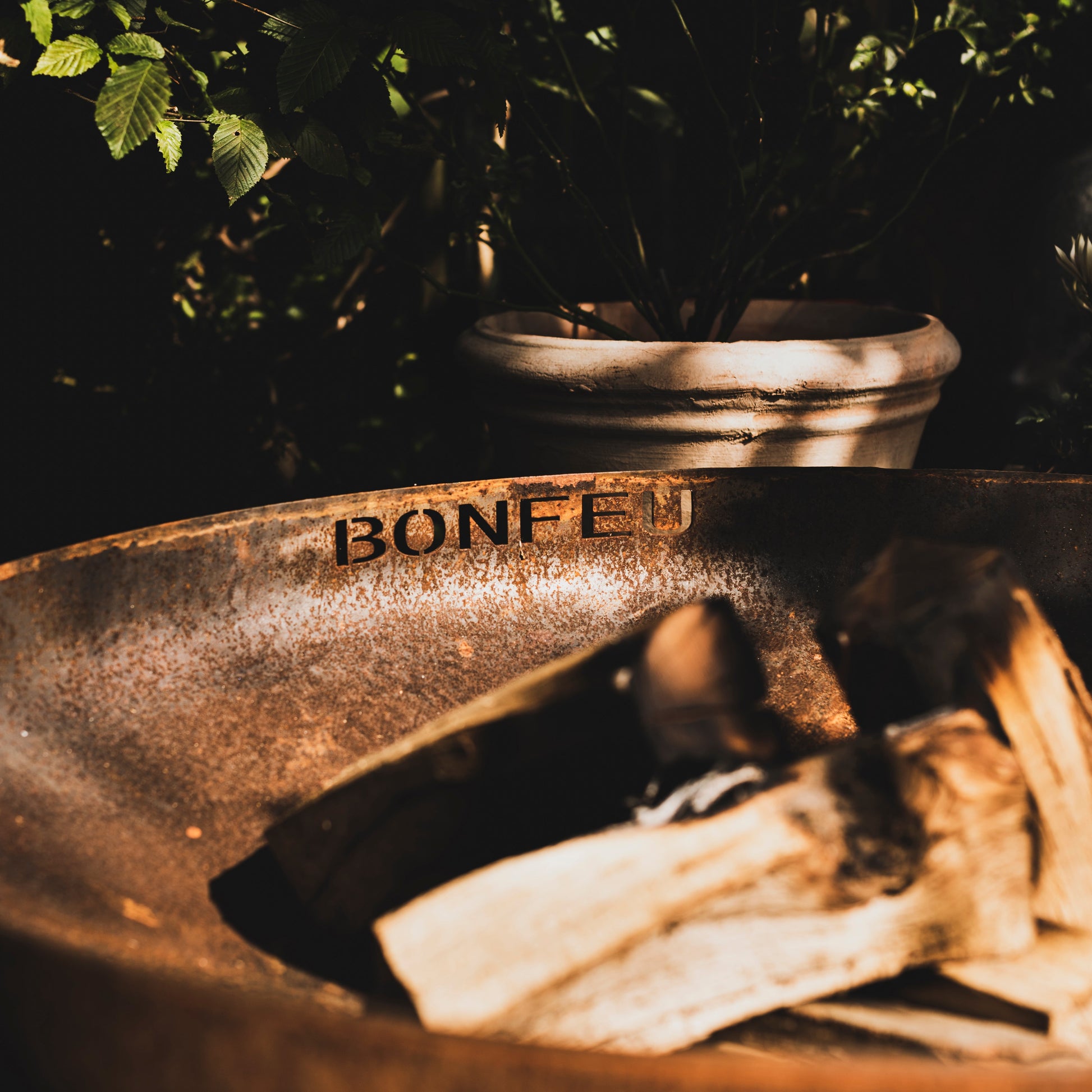 Rustic metal bowl with 'Bonfeu' branding on a dark background