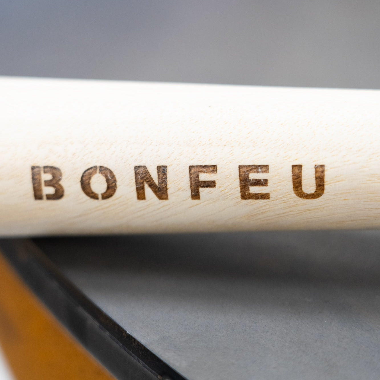 Wooden stick with 'BONFEU' branding on a blurred background
