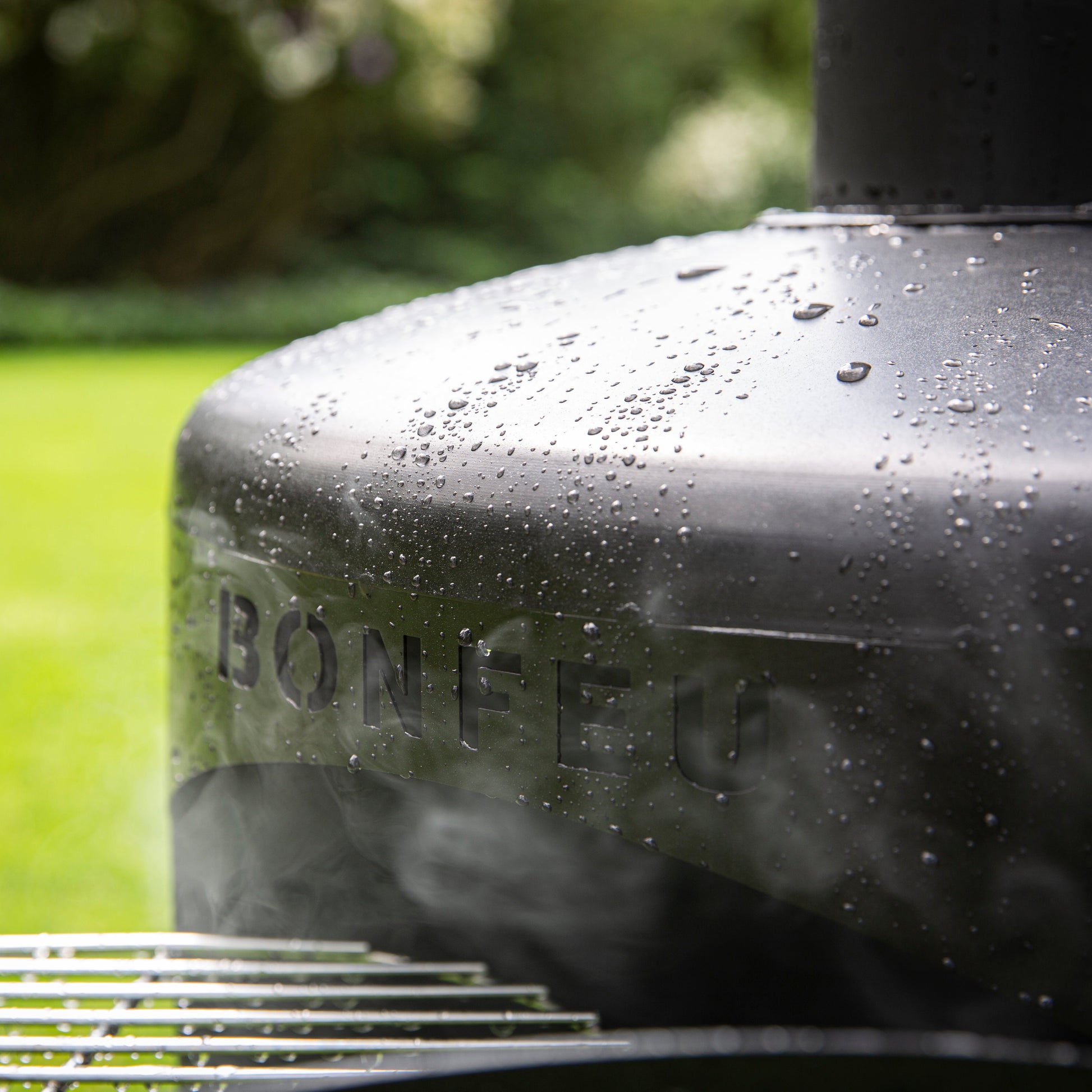 Close-up of a Bonfire grill with a blurred green lawn in the background