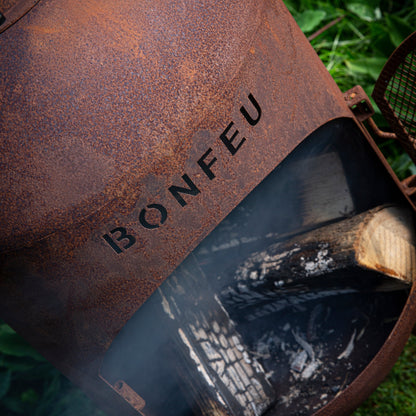 Rust-colored metal fire pit with 'BONFEU' branding on a grassy background