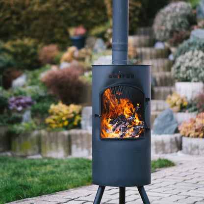 Outdoor fireplace with flames burning in a garden setting