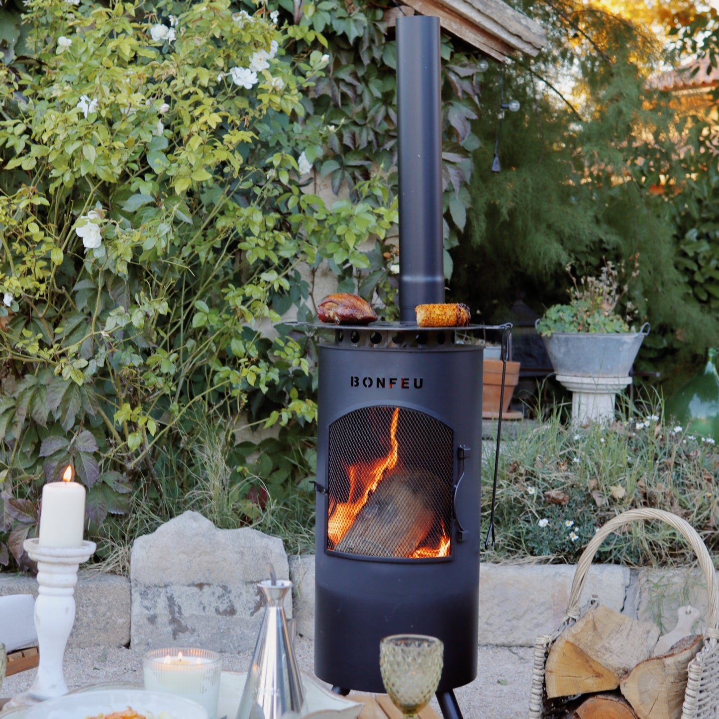 Outdoor setting with a wood stove, table, and garden decorations.
