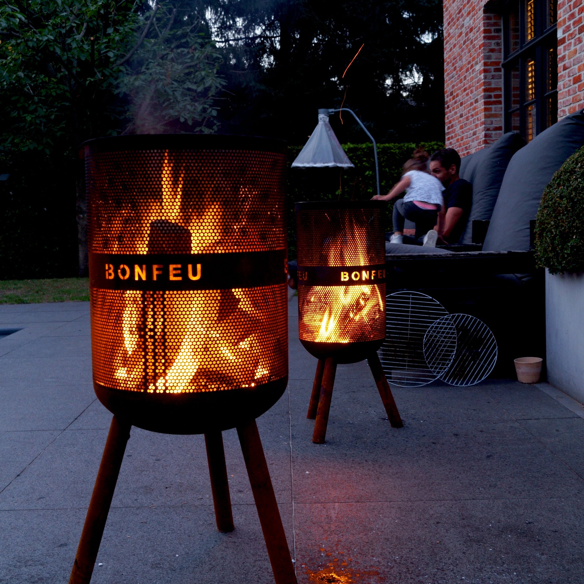 Bonfeu fire pits on a patio with people sitting nearby