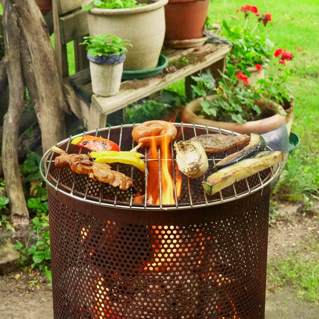 Barbecue grill with food being cooked outdoors in a garden setting