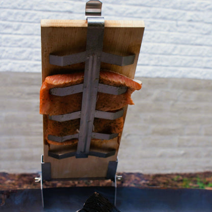 Wooden smoking device with salmon fillets over a fire