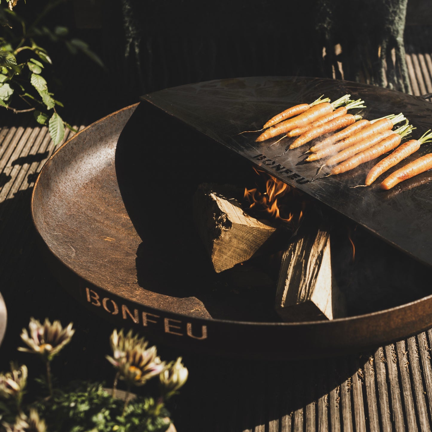Wooden fire pit with charcoal and carrots on a textured surface