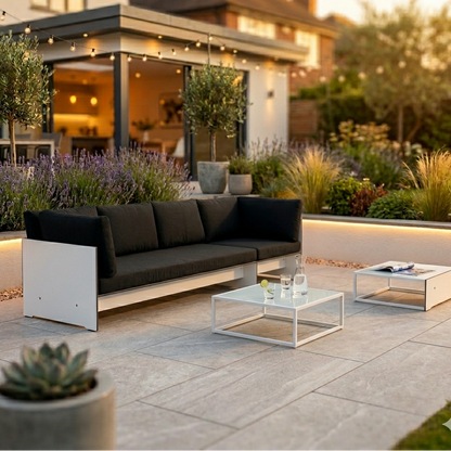conmoto RIVA Lounge Sofa White Frame with Anthracite Cushions in luxury garden UK setting 