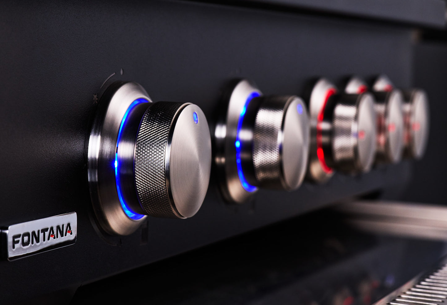 Close-up of a black Fontana grill control panel with multiple metallic knobs glowing with blue and red LED lights.